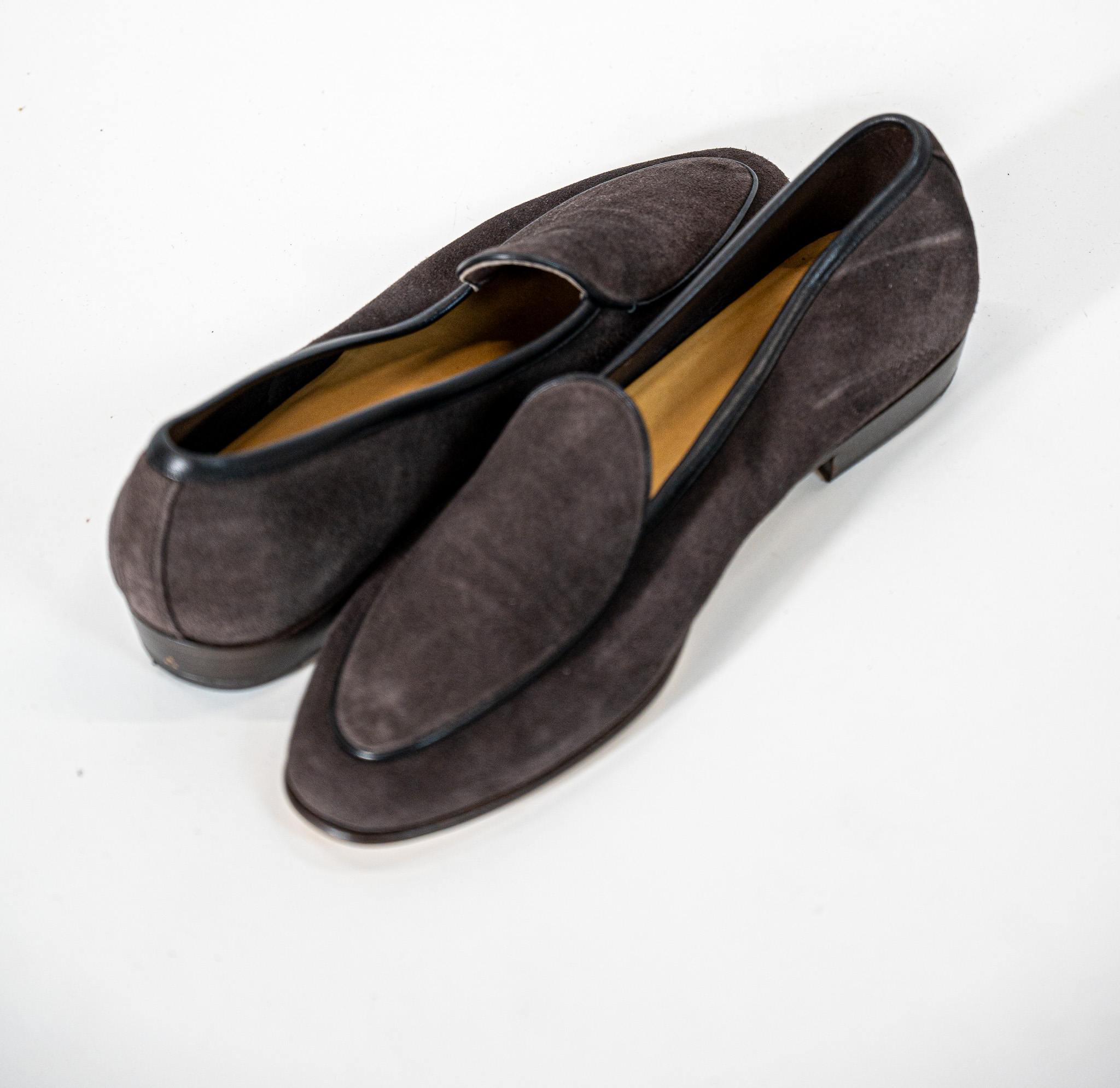 This suede leather loafer stands out for its clean, sophisticated design. Crafted from soft premium suede in rich dark brown tones, it features a sleek silhouette enhanced by contrasting leather trims that highlight its elegant character. Lightweight and versatile, it is the perfect choice for complementing both smart-casual and formal looks with effortless style.