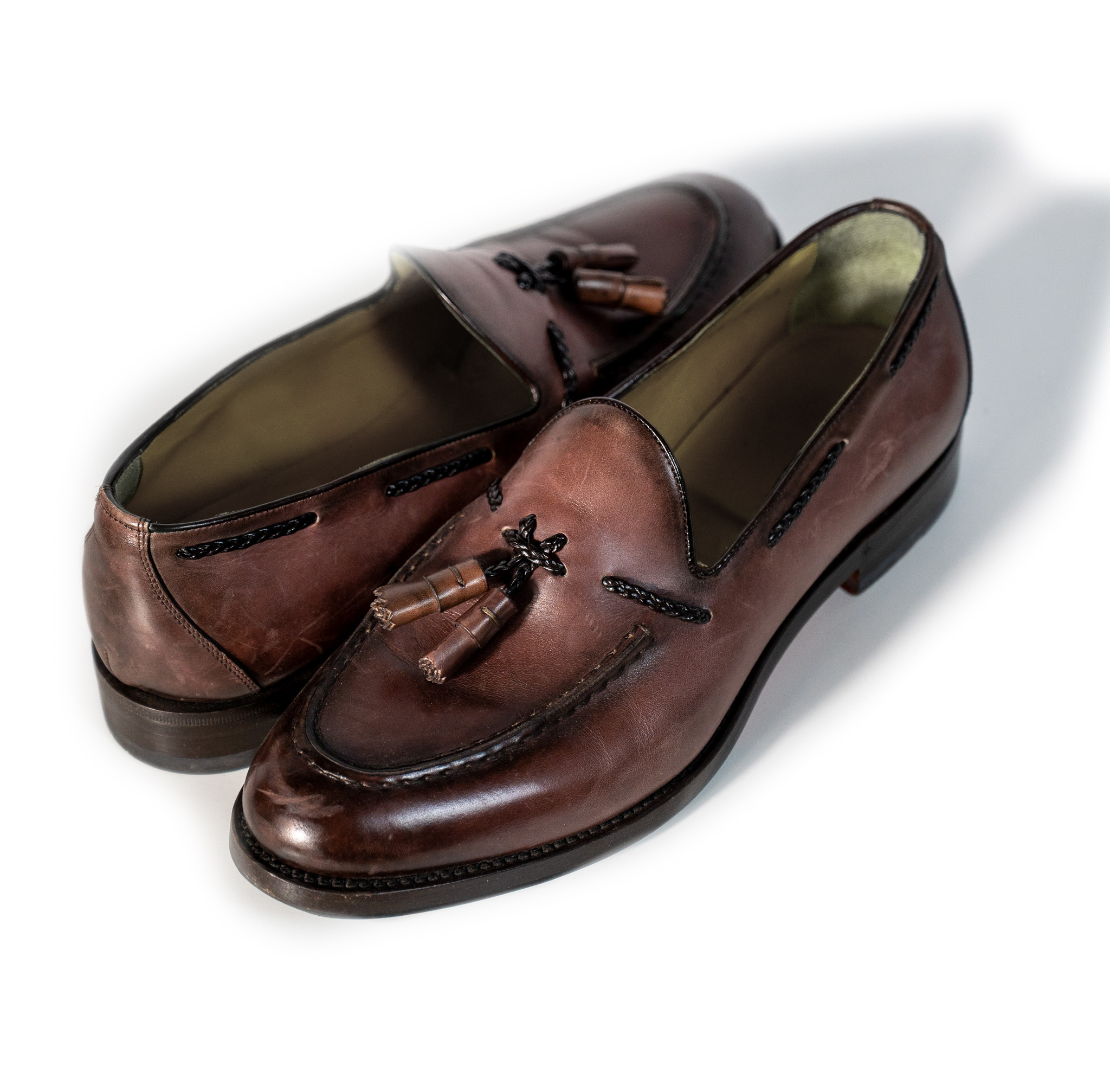 This loafer is crafted from premium leather featuring a hand-finished antique-effect patina in rich dark brown tones. The timeless design is enhanced by decorative tassels and hand-stitched detailing on the apron toe, making it a versatile choice for both formal and smart-casual looks. Expert craftsmanship and attention to detail ensure outstanding comfort, quality, and enduring style.